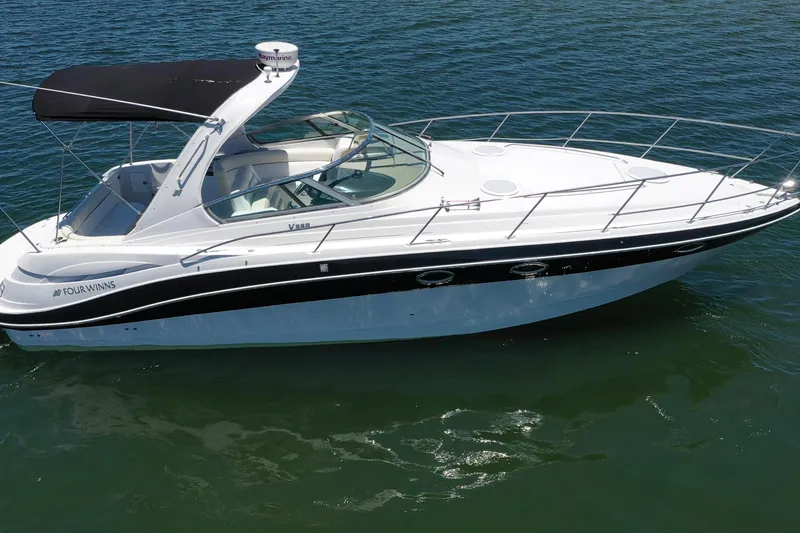 The Image of 2008 Four Winns V358 boat with black canopy cruising on water. - 1