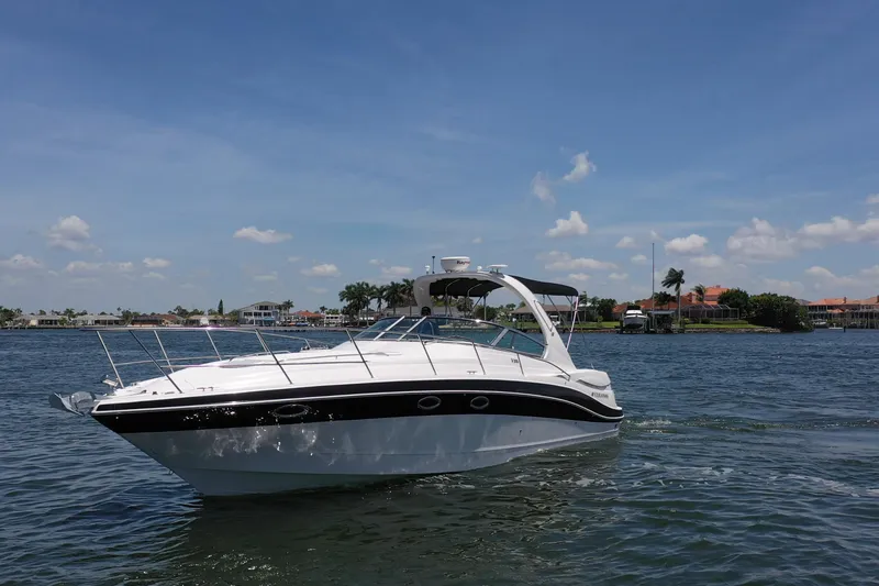 Slide: The Image of 2008 Four Winns V358 boat cruising on a sunny day with waterfront homes in the background. - 19