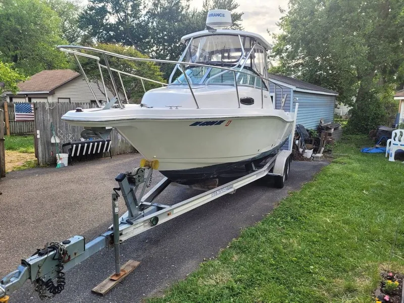 Slide: The Image of 2003 Wellcraft 240 Coastal boat on trailer in backyard. - 2