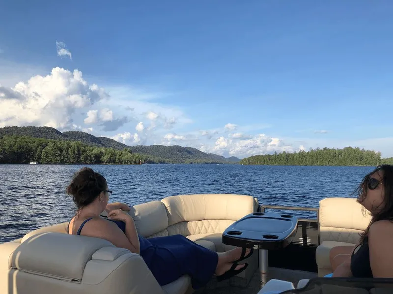 Slide: The Image of Bennington 2550QSR pontoon boat on a lake with two people, 2014 model. - 2