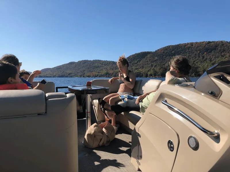 Slide: The Image of People relaxing on a 2014 Bennington 2550QSR boat on a lake. - 3