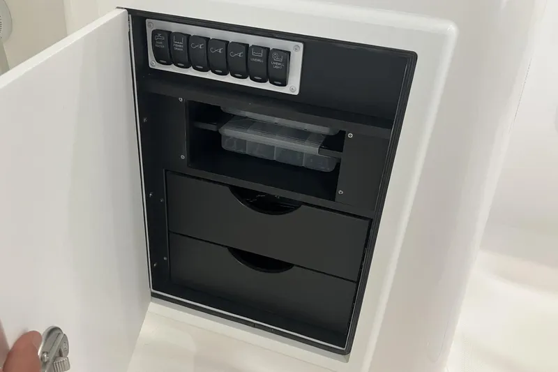 Slide: The Image of Control panel and storage compartment on 2026 Albemarle 27 Dual Console boat. - 11