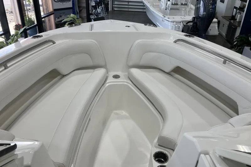 Slide: The Image of 2026 Albemarle 27 Dual Console boat interior with white cushioned seating in showroom. - 14