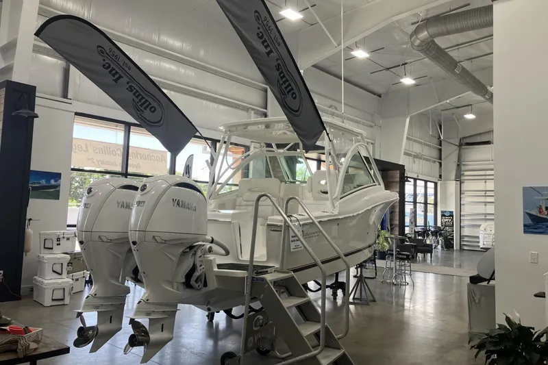 Slide: The Image of 2026 Albemarle 27 Dual Console boat displayed indoors with Yamaha engines. - 4