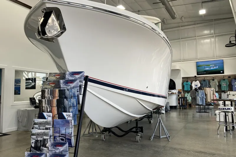 Slide: The Image of 2026 Albemarle 27 Dual Console boat displayed in showroom with merchandise and brochures. - 5
