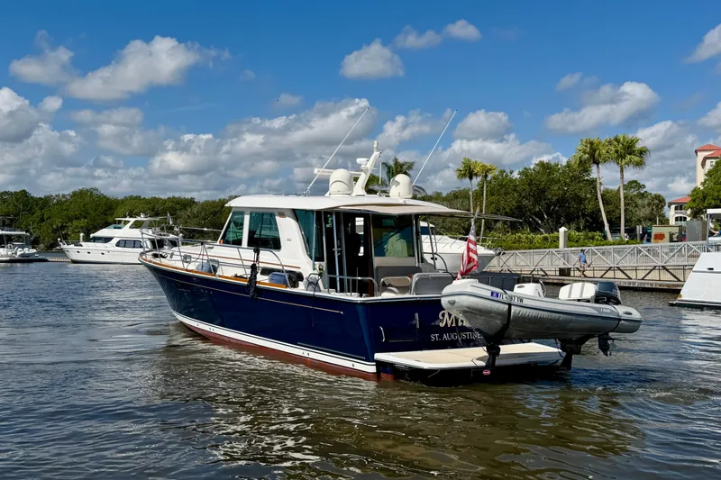 Slide: The Image of 2016 Sabre 48 Salon Express yacht docked in a marina under a blue sky. - 11