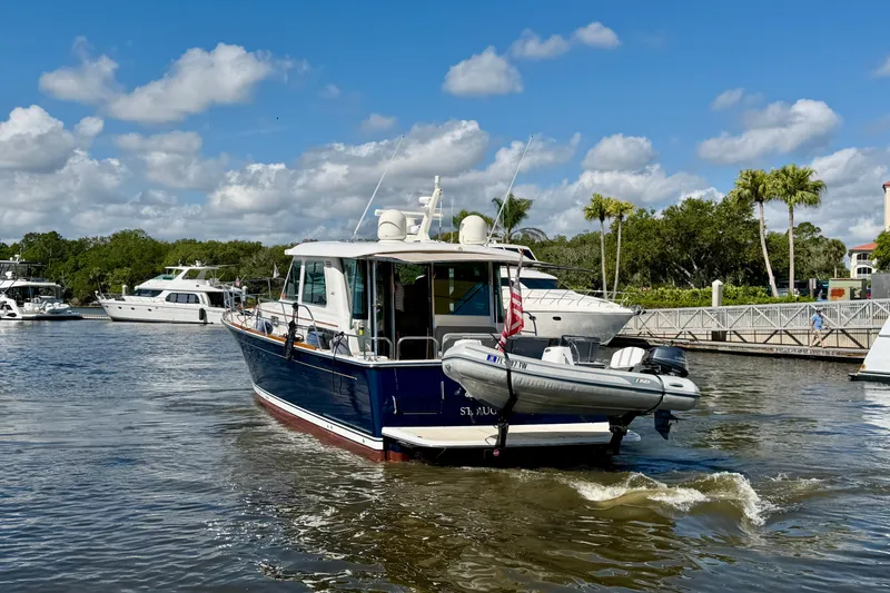 Slide: The Image of 2016 Sabre 48 Salon Express yacht cruising in a sunny marina with palm trees. - 12
