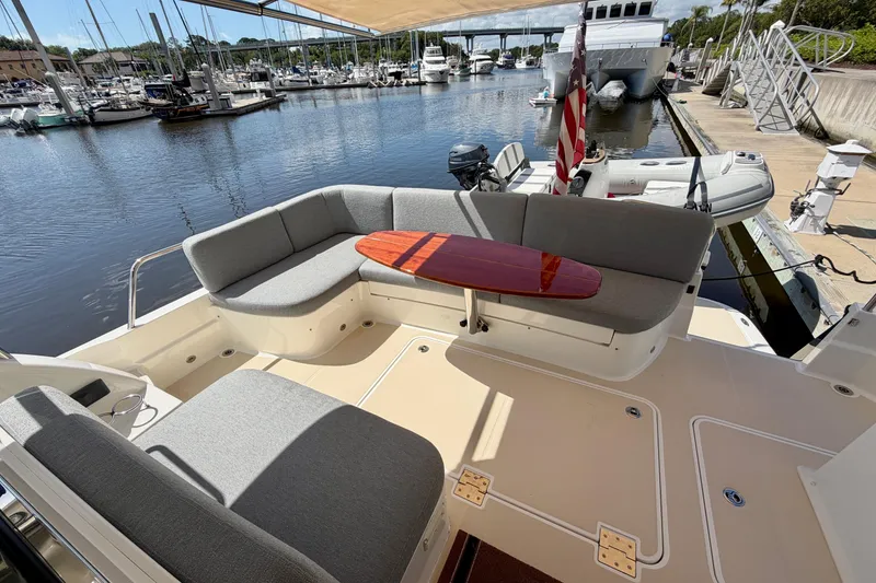 Slide: The Image of 2016 Sabre 48 Salon Express yacht with elegant seating and table, docked at a marina. - 13