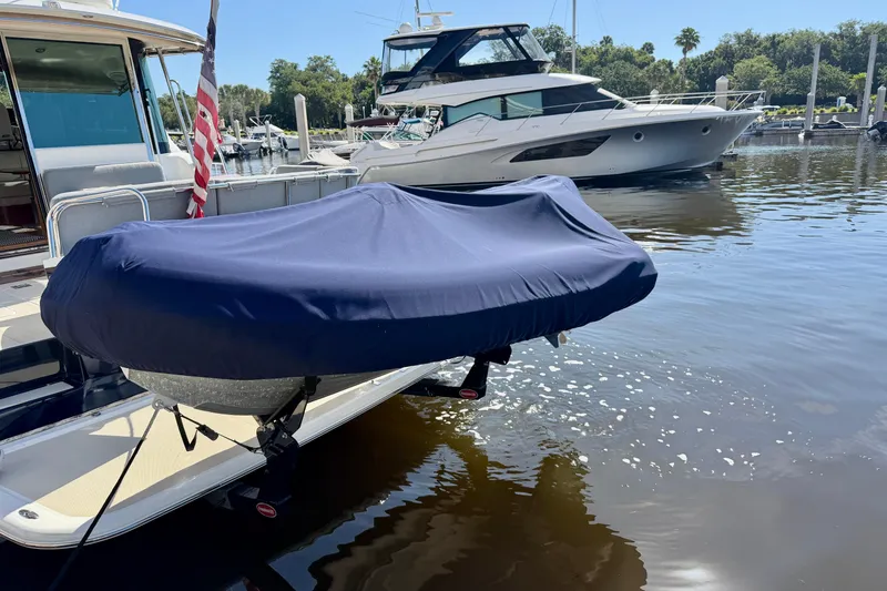 Slide: The Image of 2016 Sabre 48 Salon Express yacht docked with covered dinghy, marina background. - 15