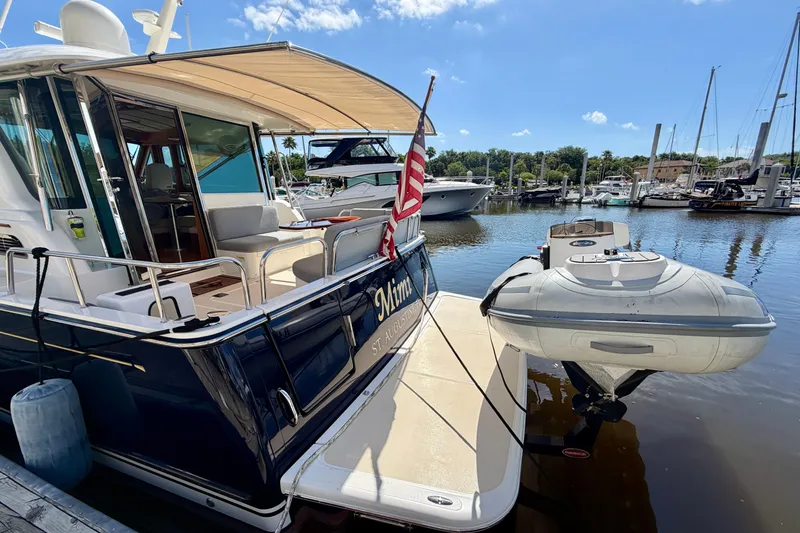 Slide: The Image of 2016 Sabre 48 Salon Express yacht docked with inflatable boat, sunny marina background. - 16