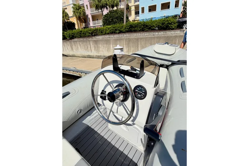 Slide: The Image of Steering console of a 2016 Sabre 48 Salon Express boat docked near colorful buildings. - 17