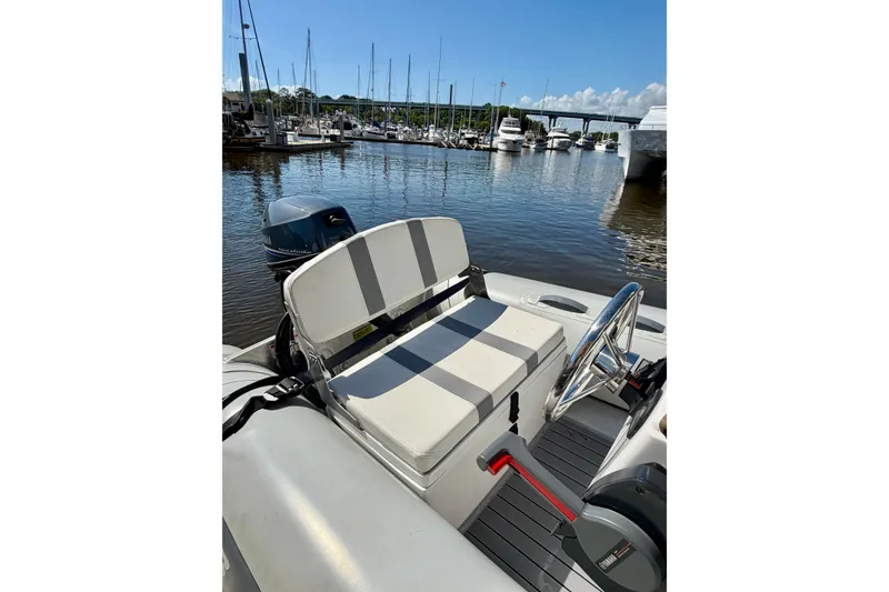 Slide: The Image of 2016 Sabre 48 Salon Express boat interior with steering wheel, docked at marina. - 18