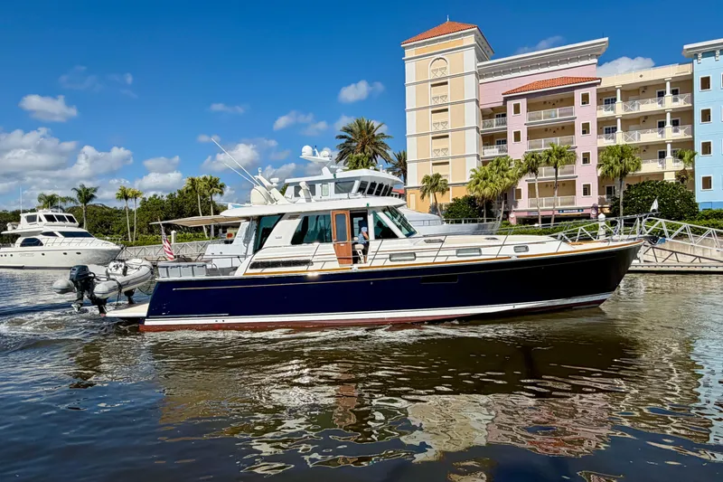 Slide: The Image of 2016 Sabre 48 Salon Express yacht cruising near colorful waterfront buildings. - 2