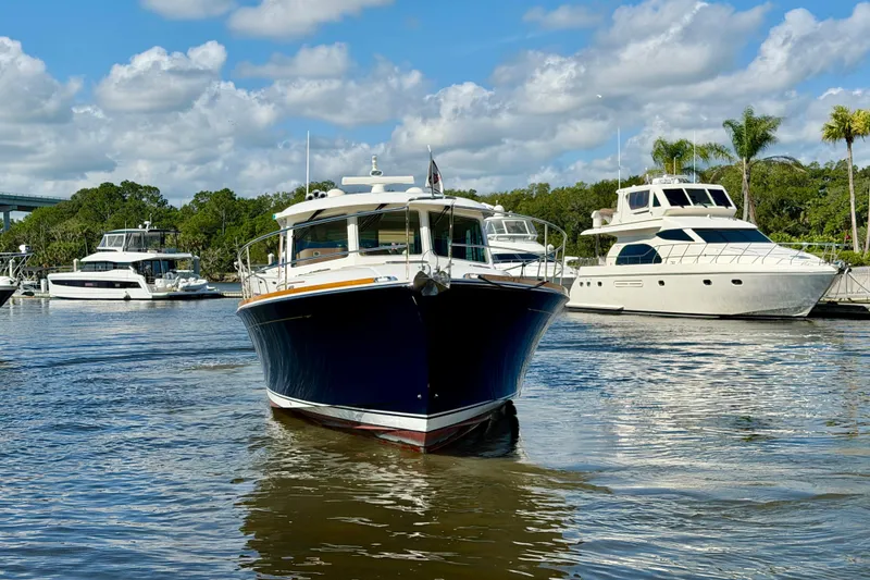 Slide: The Image of 2016 Sabre 48 Salon Express yacht docked in a marina under a partly cloudy sky. - 4