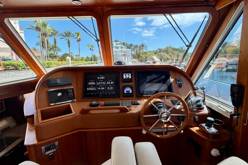 Slide: The Image of 2016 Sabre 48 Salon Express helm with navigation screens and steering wheel, dockside view. - 40
