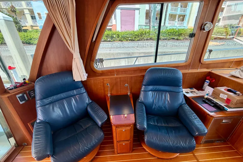 Slide: The Image of Interior of 2016 Sabre 48 Salon Express with leather chairs and wooden accents. - 44