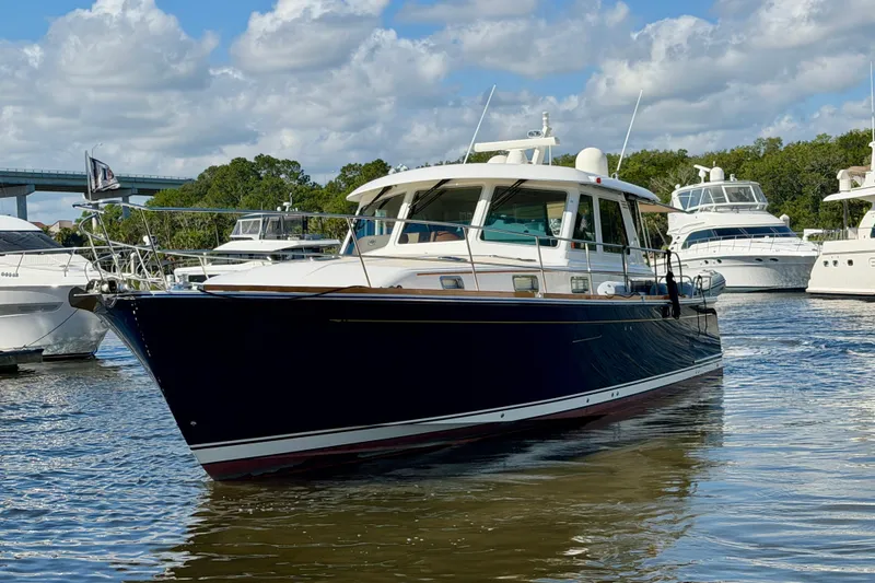 Slide: The Image of 2016 Sabre 48 Salon Express yacht on water, surrounded by other boats, under a partly cloudy sky. - 5