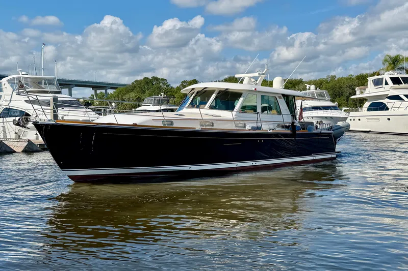 Slide: The Image of 2016 Sabre 48 Salon Express yacht docked in a marina under a cloudy sky. - 6