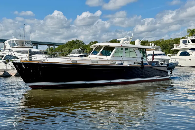 Slide: The Image of 2016 Sabre 48 Salon Express yacht docked in a marina under a blue sky. - 7