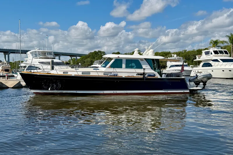 Slide: The Image of 2016 Sabre 48 Salon Express yacht docked in a marina under a partly cloudy sky. - 8