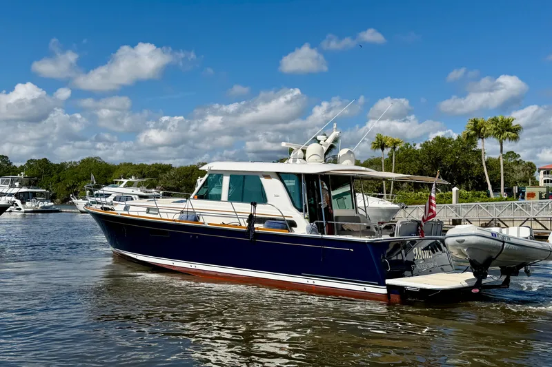Slide: The Image of 2016 Sabre 48 Salon Express yacht cruising on a sunny day with palm trees in the background. - 9