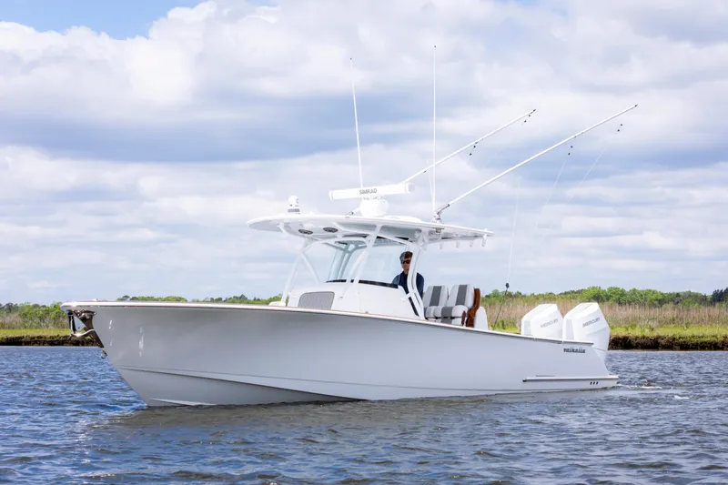 The Image of 2025 Valhalla Boatworks V-33 cruising on a calm waterway under a cloudy sky. - 0
