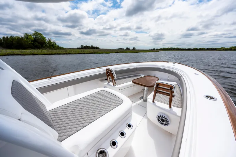 Slide: The Image of 2025 Valhalla Boatworks V-33 interior with seating and table on calm water. - 13