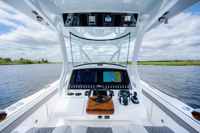 Slide: The Image of 2025 Valhalla Boatworks V-33 helm with advanced navigation system on a serene waterway. - 30