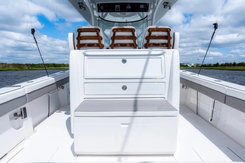 Slide: The Image of 2025 Valhalla Boatworks V-33 interior with seating and storage, under a blue sky. - 36