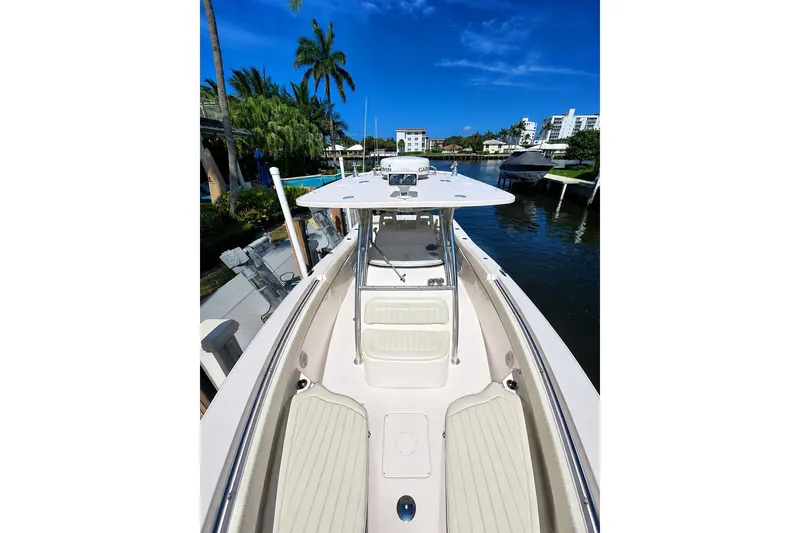 Slide: The Image of 2014 Grady-White Canyon 306 boat docked by palm trees and waterfront homes. - 10