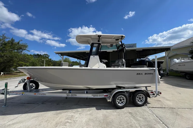 The Image of 2027 Sea Born LX22 Center Console boat on trailer under blue sky. - 1