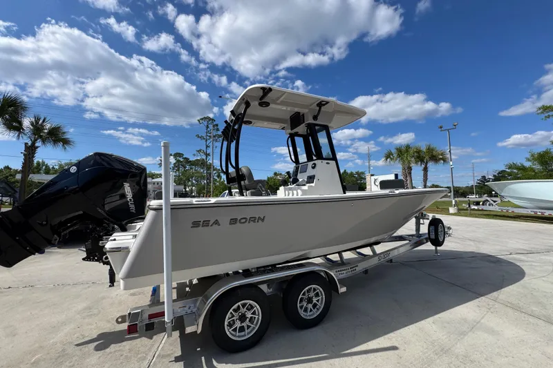 Slide: The Image of 2027 Sea Born LX22 Center Console boat on trailer under blue sky. - 10