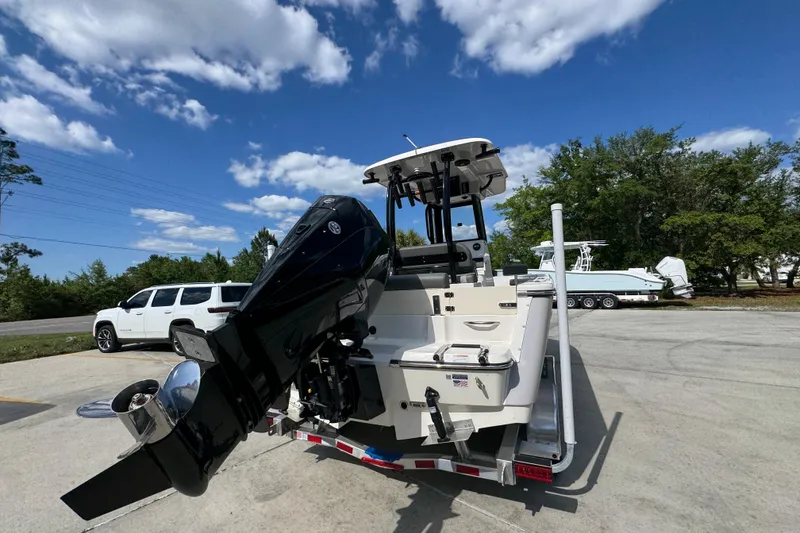 Slide: The Image of 2027 Sea Born LX22 Center Console boat on trailer, with outboard motor, under clear blue sky. - 12