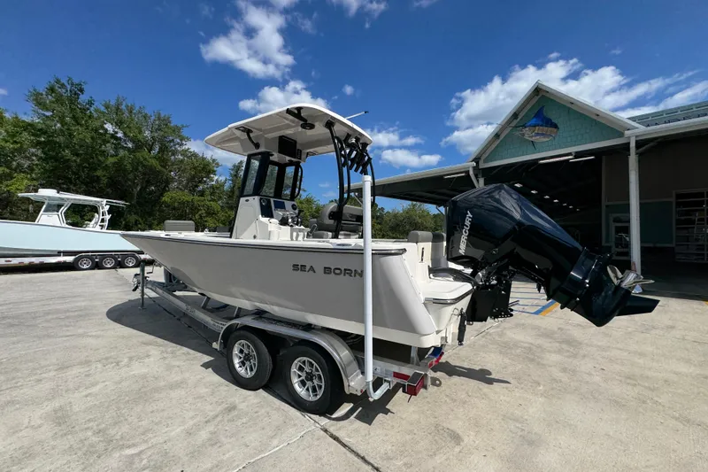 Slide: The Image of 2027 Sea Born LX22 Center Console boat on trailer, parked outdoors under blue sky. - 15
