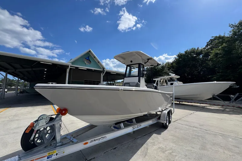 Slide: The Image of 2027 Sea Born LX22 Center Console boat on trailer under clear blue sky. - 3