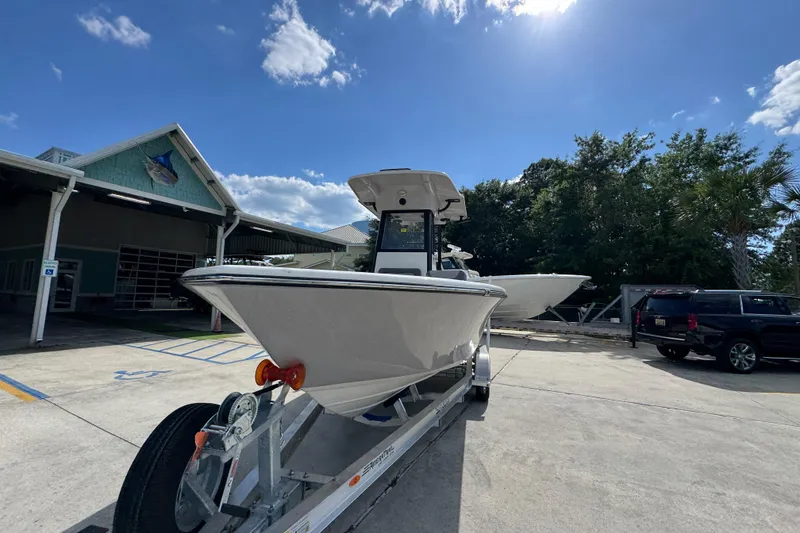 Slide: The Image of 2027 Sea Born LX22 Center Console boat on trailer under clear blue sky. - 4
