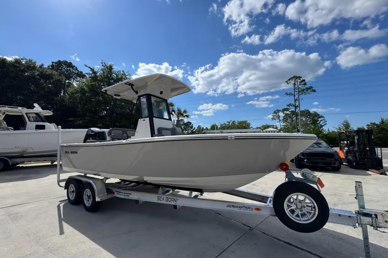 Slide: The Image of 2027 Sea Born LX22 Center Console boat on trailer under blue sky. - 7