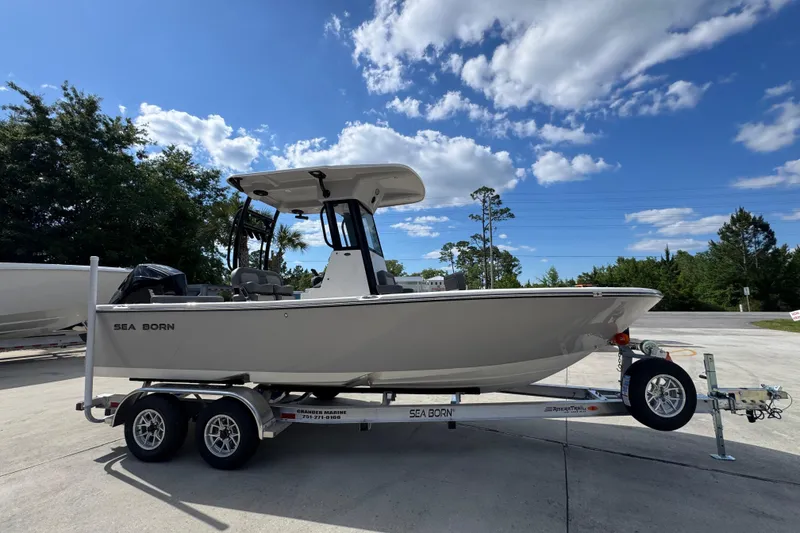 Slide: The Image of 2027 Sea Born LX22 Center Console boat on trailer under blue sky. - 8