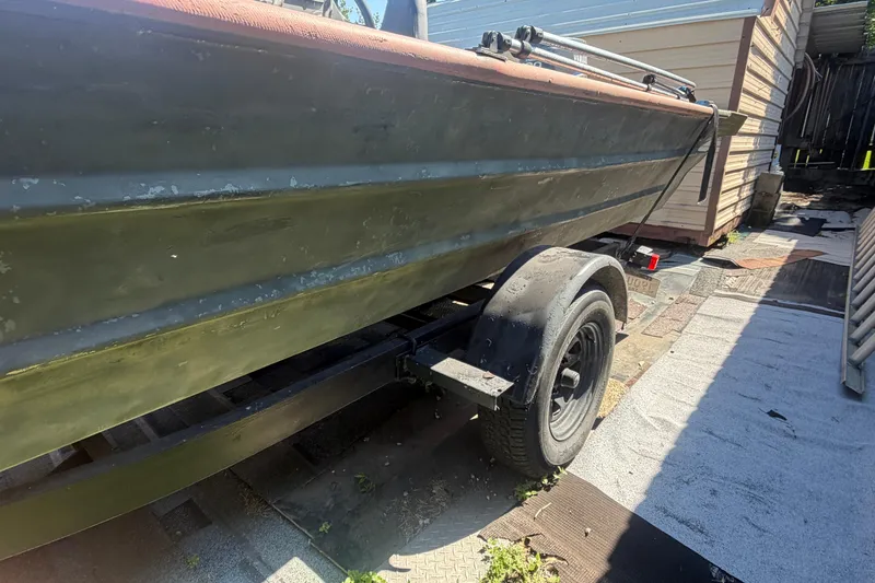 Slide: The Image of 2005 Southfork 1860 boat on trailer, parked beside a building. - 12