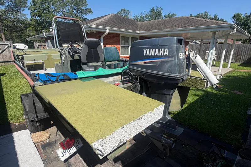 Slide: The Image of Boat with Yamaha 90 engine, Southfork 1860 model, parked in a residential yard. - 13