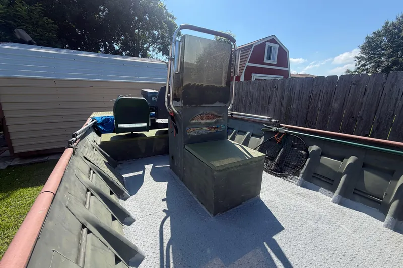 Slide: The Image of 2005 Southfork 1860 boat with center console, parked outdoors near a wooden fence. - 4