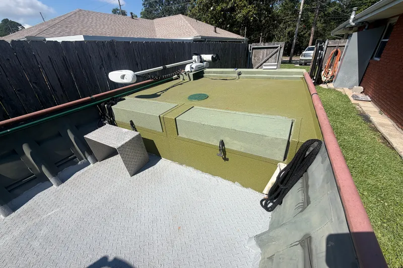 Slide: The Image of 2005 Southfork 1860 boat with green deck, parked in a backyard. - 5