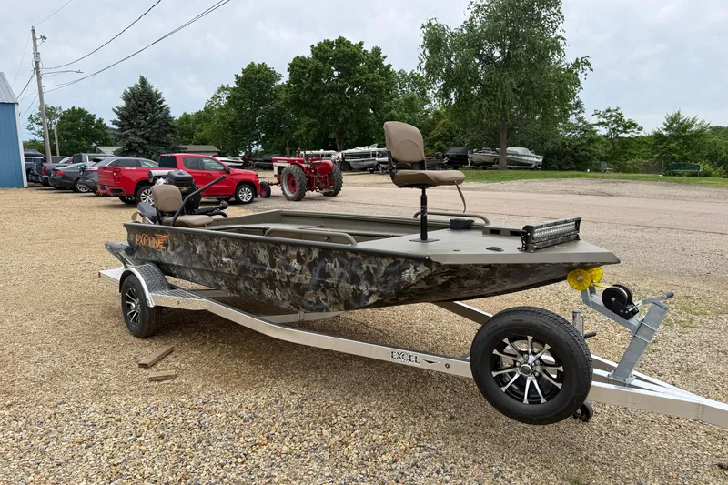 Slide: The Image of 2026 Excel 1860 Shallow Water F4 boat on trailer, parked outdoors. - 1