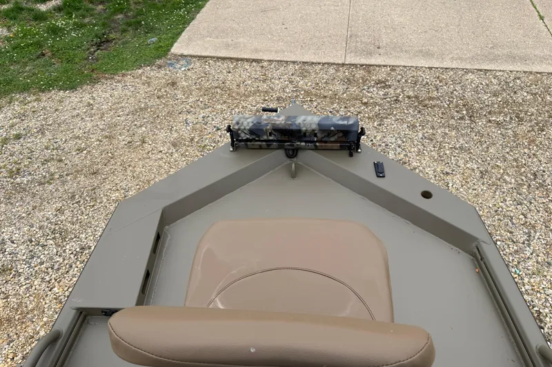 Slide: The Image of 2026 Excel 1860 Shallow Water F4 boat with beige seating on gravel surface. - 12