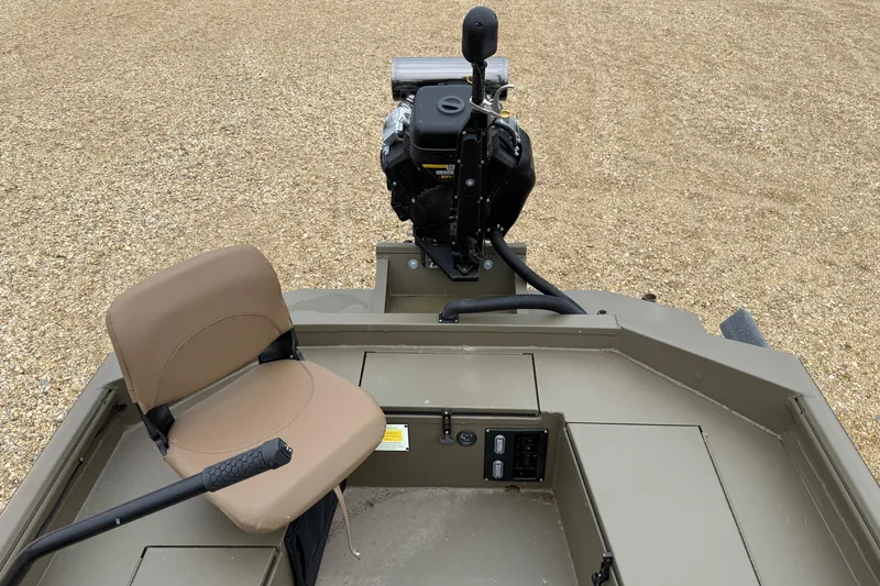 Slide: The Image of 2026 Excel 1860 Shallow Water F4 boat interior with seat and motor on gravel. - 18