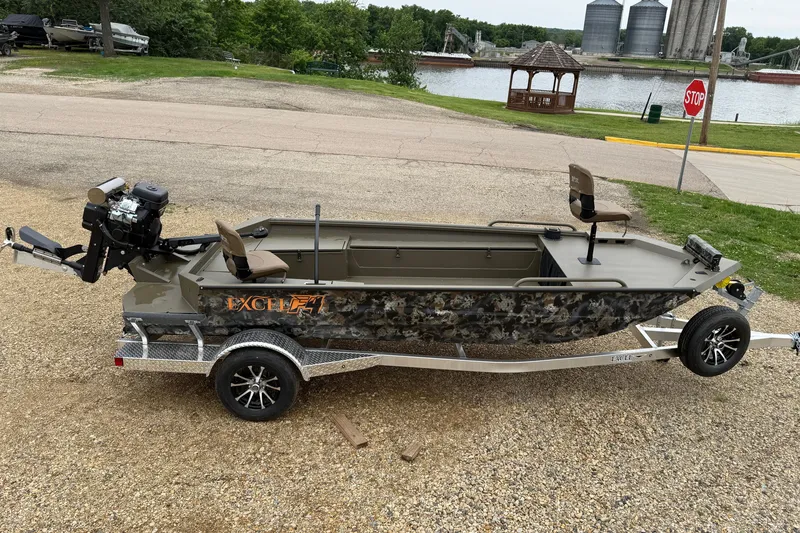 Slide: The Image of 2026 Excel 1860 Shallow Water F4 boat on trailer near river and gazebo. - 3