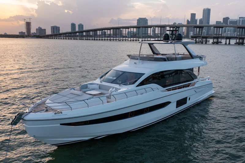 The Image of Luxurious 2022 Azimut 78 yacht cruising near city skyline at sunset. - 0
