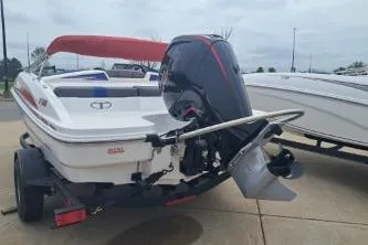 Slide: The Image of 2023 Tahoe T18 boat with outboard motor on a trailer, parked outdoors. - 3