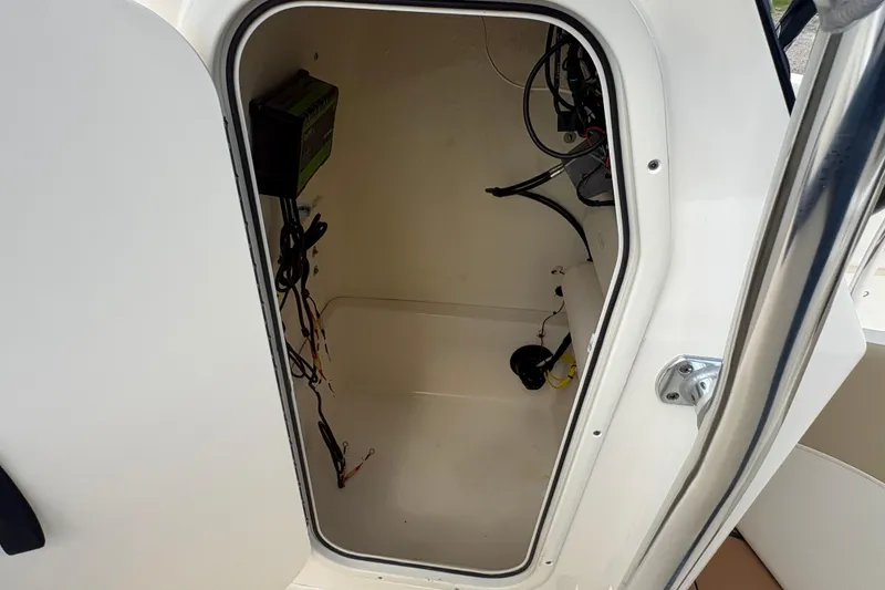 Slide: The Image of 2024 Bulls Bay 230 Center Console storage compartment with wiring and equipment. - 12