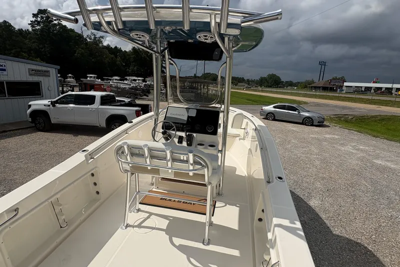 Slide: The Image of 2024 Bulls Bay 230 Center Console boat with modern helm and seating, parked outdoors. - 8